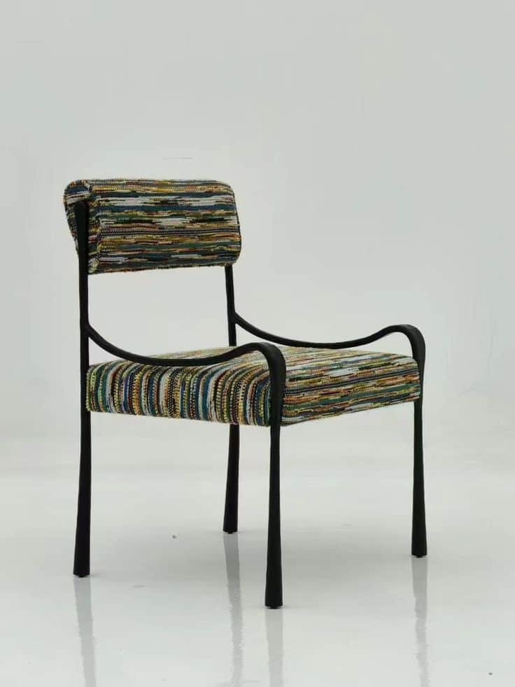 An accent armchair featuring a minimalist black tubular metal frame with a rectangular backrest and… — 3D model