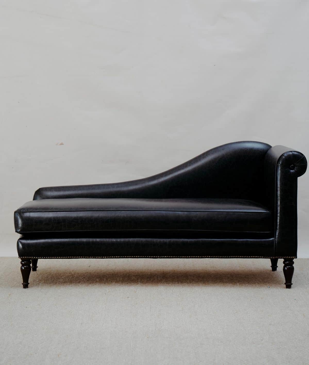 A traditional black leather chaise lounge featuring classic design elements such as a rolled arm, cu… — 3D model