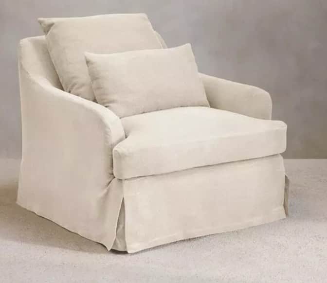 A light-colored, upholstered armchair featuring a loose slipcover design and a skirted base. It has… — free OBJ 3D model