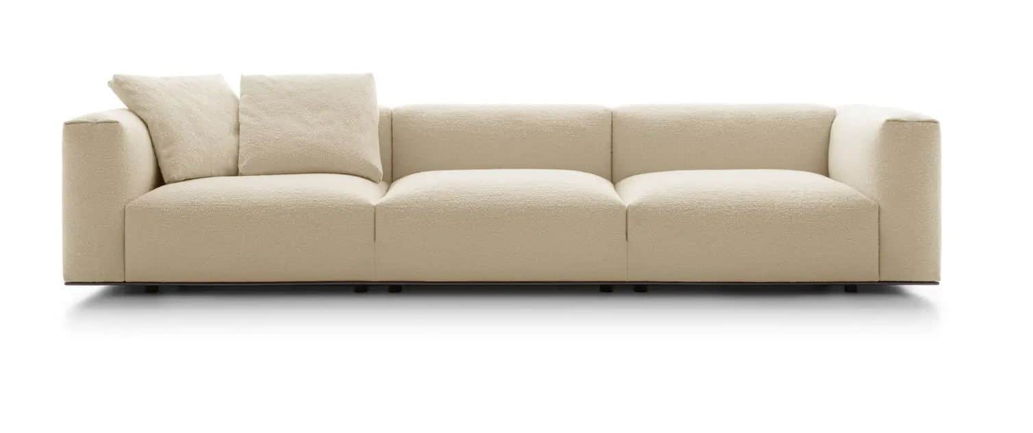 A contemporary three-seater sofa upholstered in a cream-colored boucle fabric. It features a low-pro… — 3D model