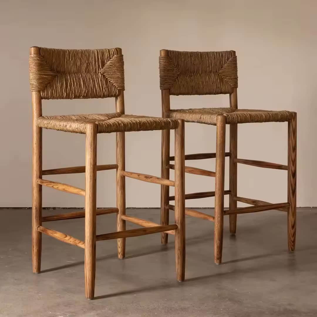 A natural wood bar stool featuring a woven rope seat and backrest, supported by four tapered wooden… — 3D model