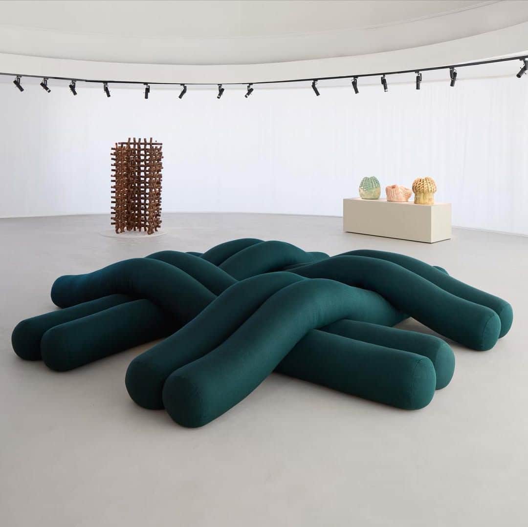 A contemporary low-profile ottoman constructed from multiple thick, tubular segments that are braide… — 3D model