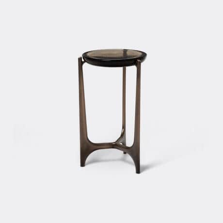 A round-topped side table with a dark, textured surface and a bronze-colored metal base. The base fe… — 3D model