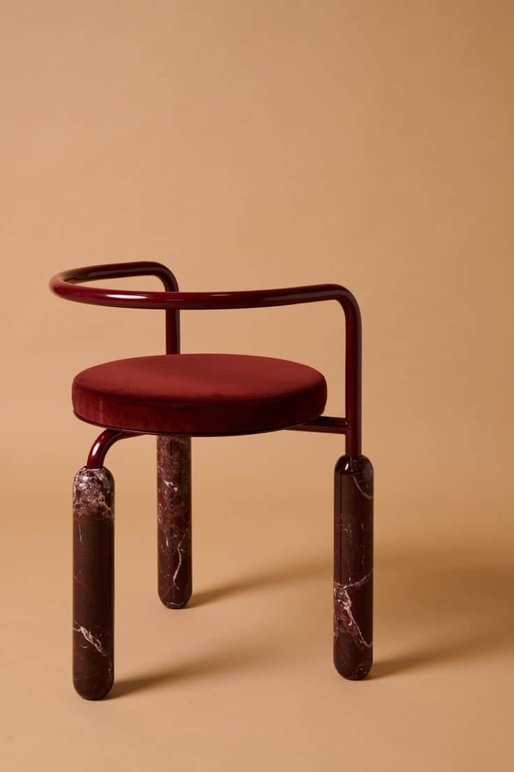 A contemporary accent chair featuring a circular deep red velvet upholstered seat, supported by a cu… — 3D model