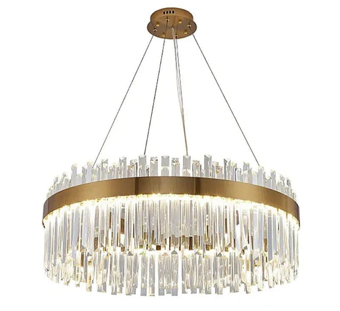 A modern circular chandelier featuring a polished brass frame that encases multiple tiers of clear,… — 3D model