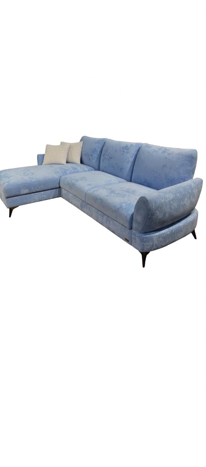 A light blue sectional sofa with a chaise lounge extension. The sofa features three back cushions an… — 3D model
