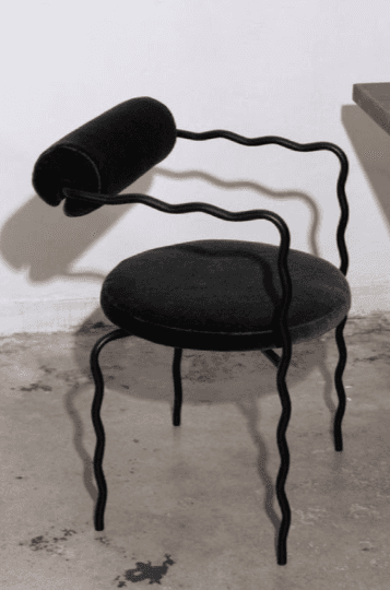 A black armchair with a uniquely designed frame and upholstery. The frame is constructed from thin,… — 3D model