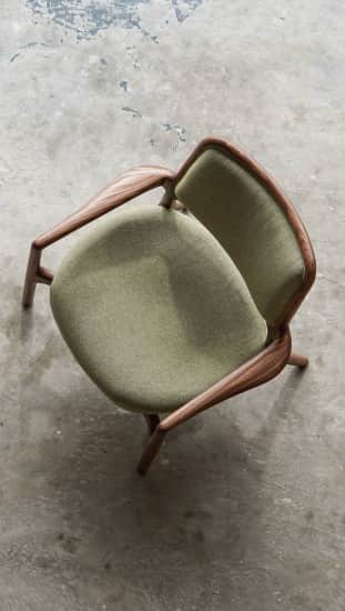 A modern accent chair with a wooden frame and upholstered seat and backrest. The frame has a distinc… — free OBJ 3D model