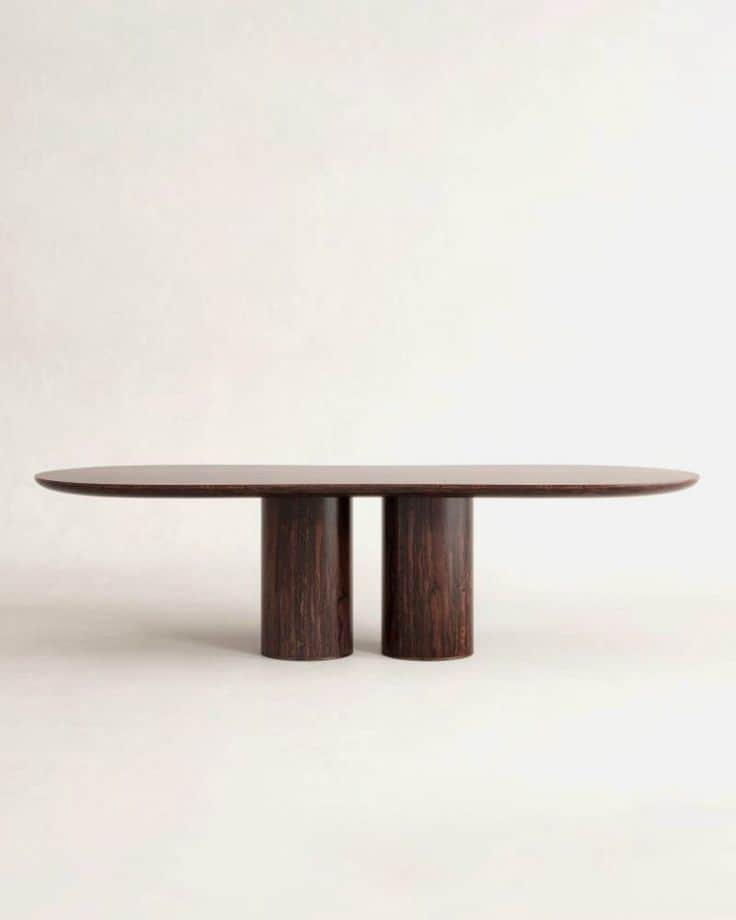 An oval dining table with a dark wood finish, supported by two cylindrical legs positioned centrally… — free SKP 3D model