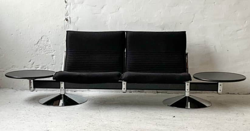 A two-seater sofa with attached side tables. The sofa features black upholstered seats and backrests… — free GLTF 3D model