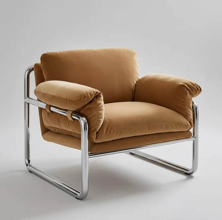 A modern armchair featuring a tubular chrome-plated steel frame and plush, upholstered cushions in a… — 3D model