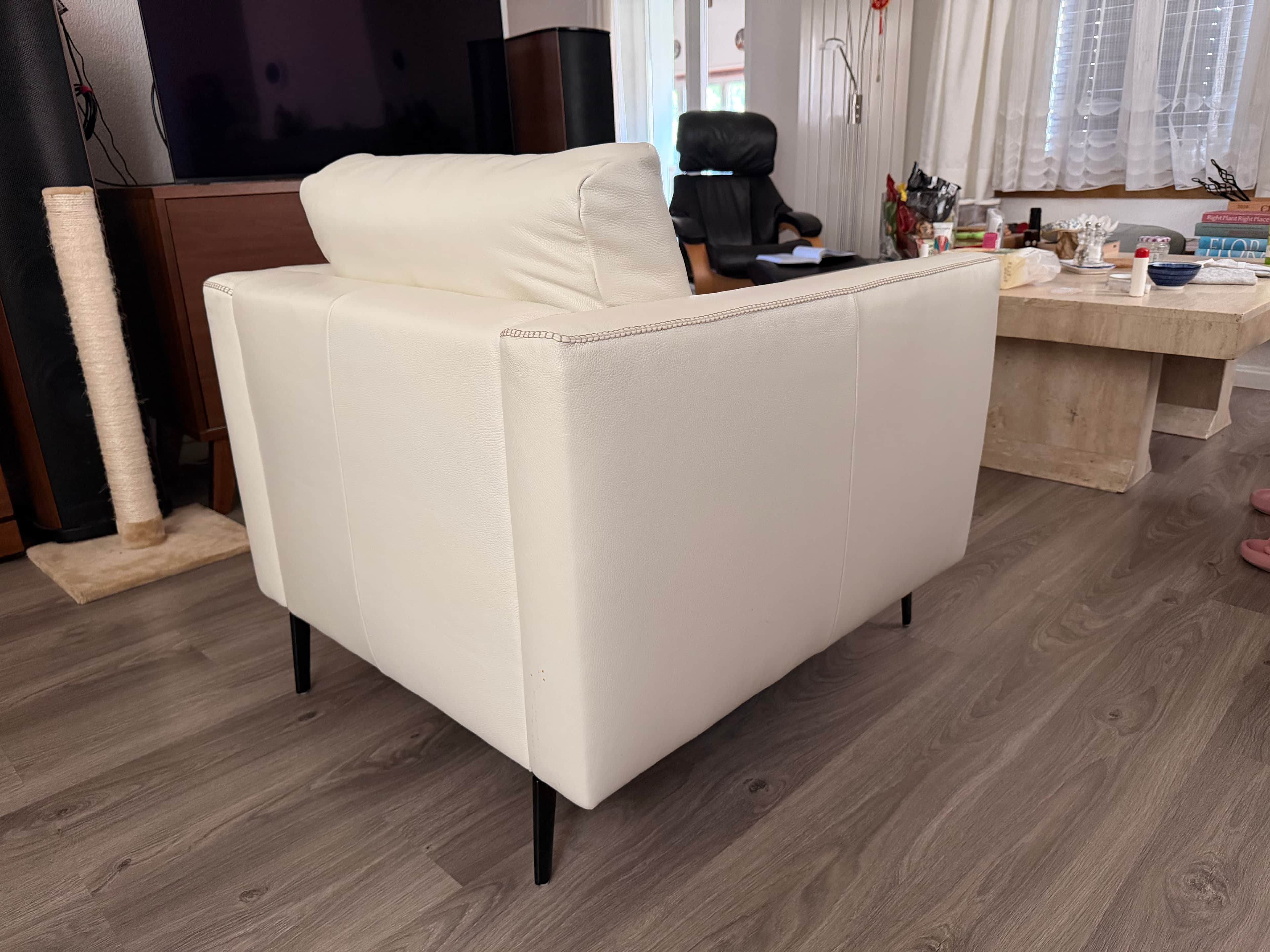 A modern white sofa with a tufted backrest and armrests, upholstered in a material that appears to b… — 3D model