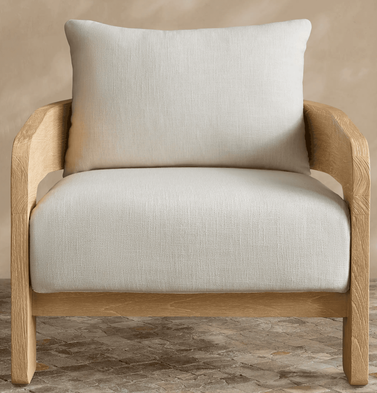A modern upholstered armchair featuring a light-toned wooden frame and thick, cream-colored fabric c… — 3D model