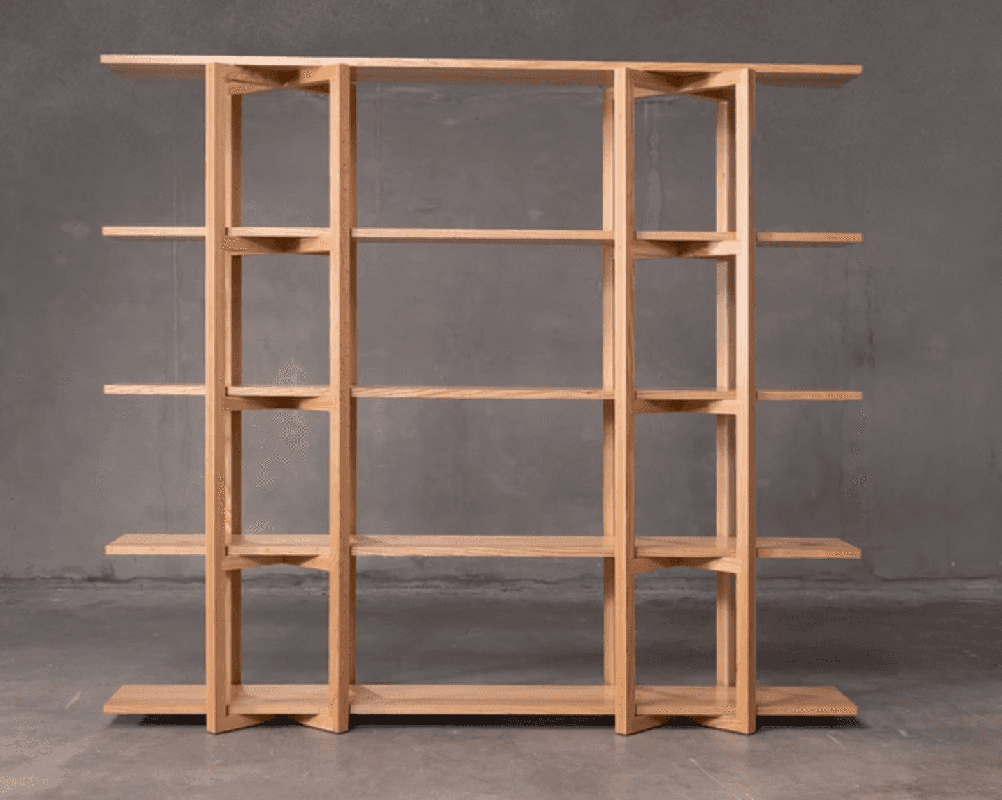 A modern, minimalist bookshelf with five shelves supported by a light wood frame. The shelves are ho… — 3D model