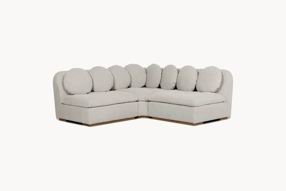 A modular sectional sofa with a low profile and rounded arms. It features a light-colored fabric uph… — 3D model