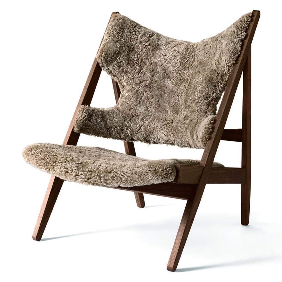 A lounge chair with a distinctive, organic shape. The frame is constructed from dark wood, featuring… — 3D model
