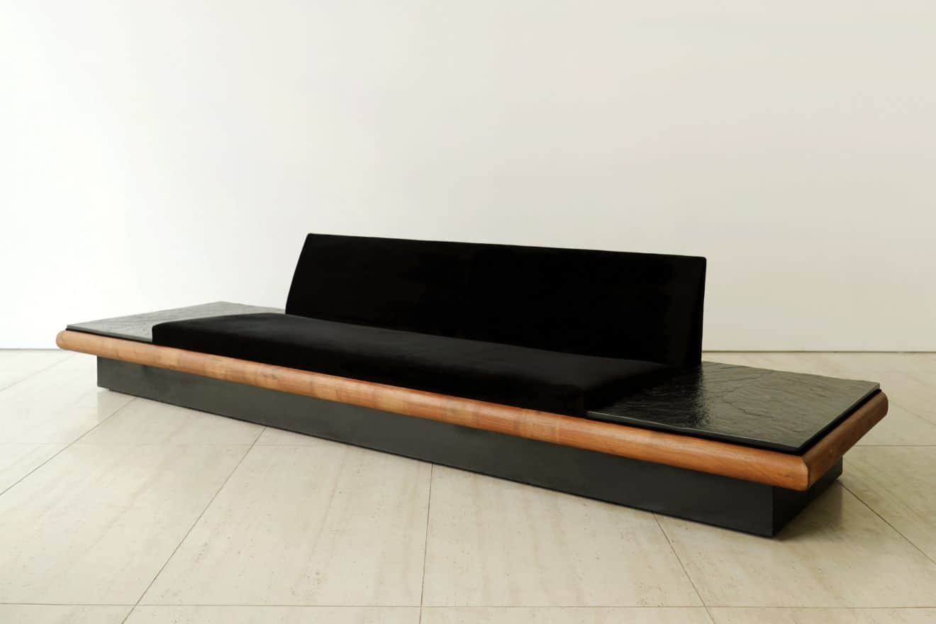 A long, low, contemporary sofa featuring a black velvet upholstered seat and a gently curved backres… — 3D model