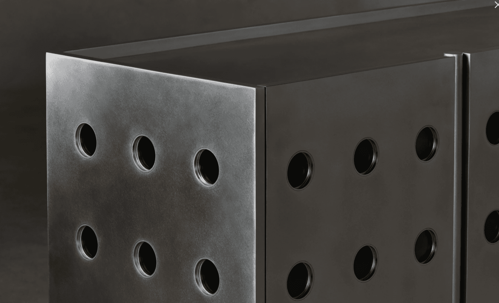 A modern cabinet with a brushed metal finish, featuring a series of circular cutouts on its visible… — 3D model