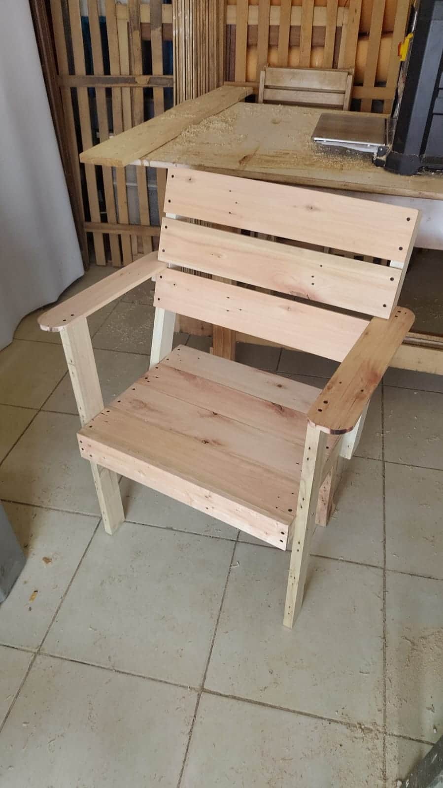 An unfinished slatted wooden armchair, constructed from light-colored timber boards. The design feat… — free OBJ 3D model