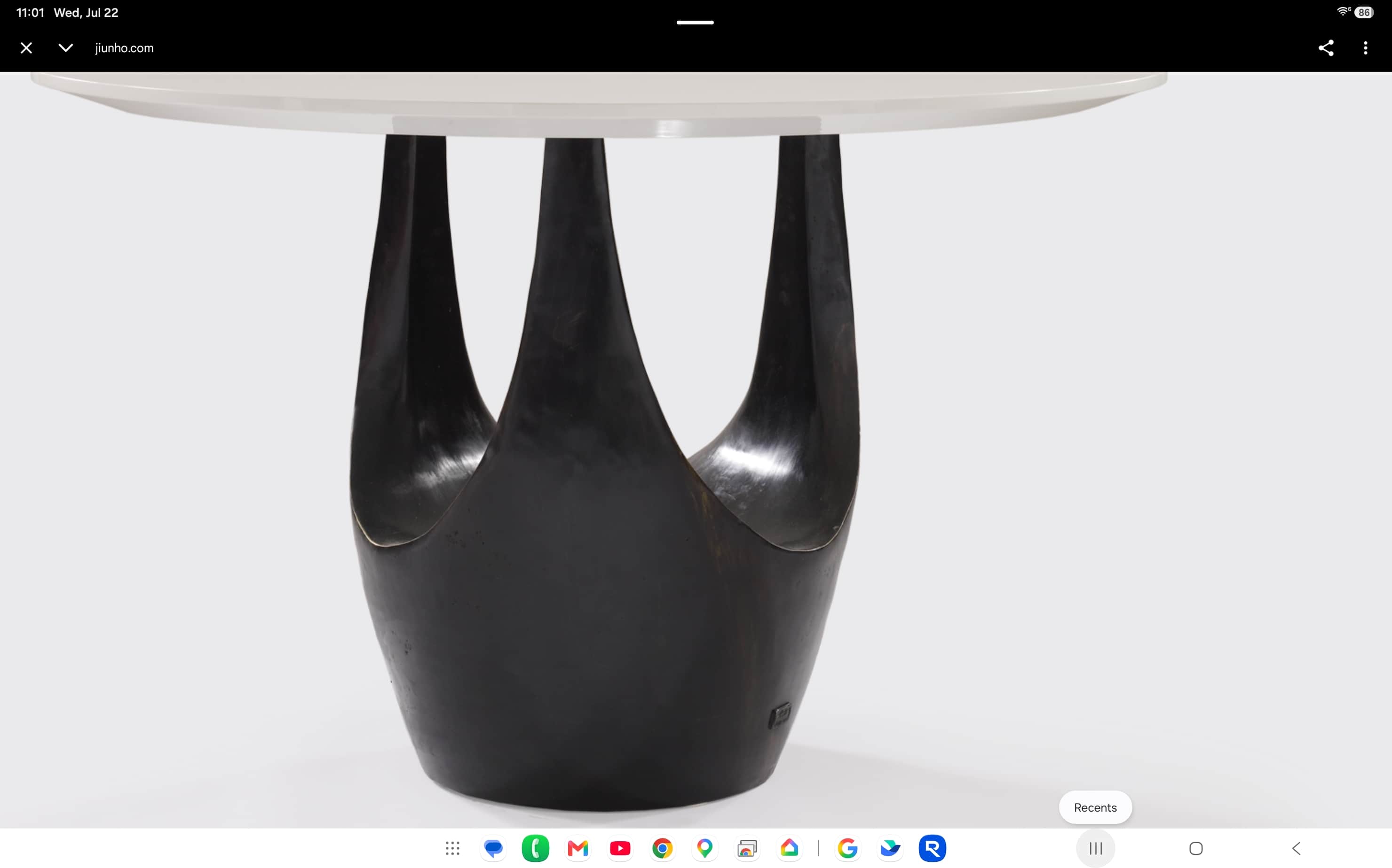 A contemporary dining table featuring a round white tabletop supported by a distinctive dark, sculpt… — 3D model