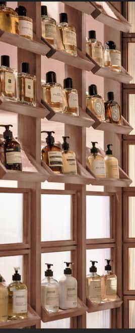 A wooden shelving unit with multiple angled shelves designed to display bottles. The unit has a ligh… — 3D model