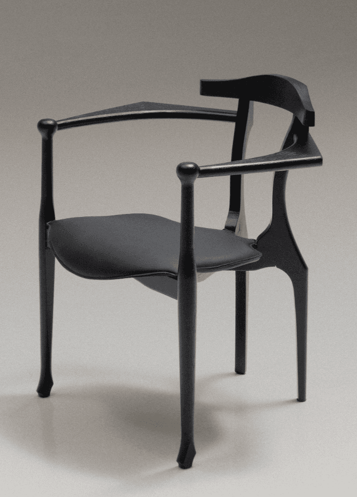 A contemporary armchair featuring a sculptural black-stained wooden frame and an upholstered seat pa… — 3D model