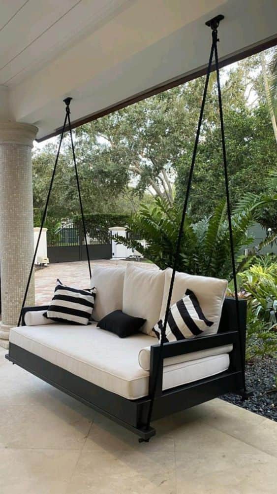 A modern suspended outdoor daybed featuring a rectangular black wooden frame, thick white upholstere… — 3D model