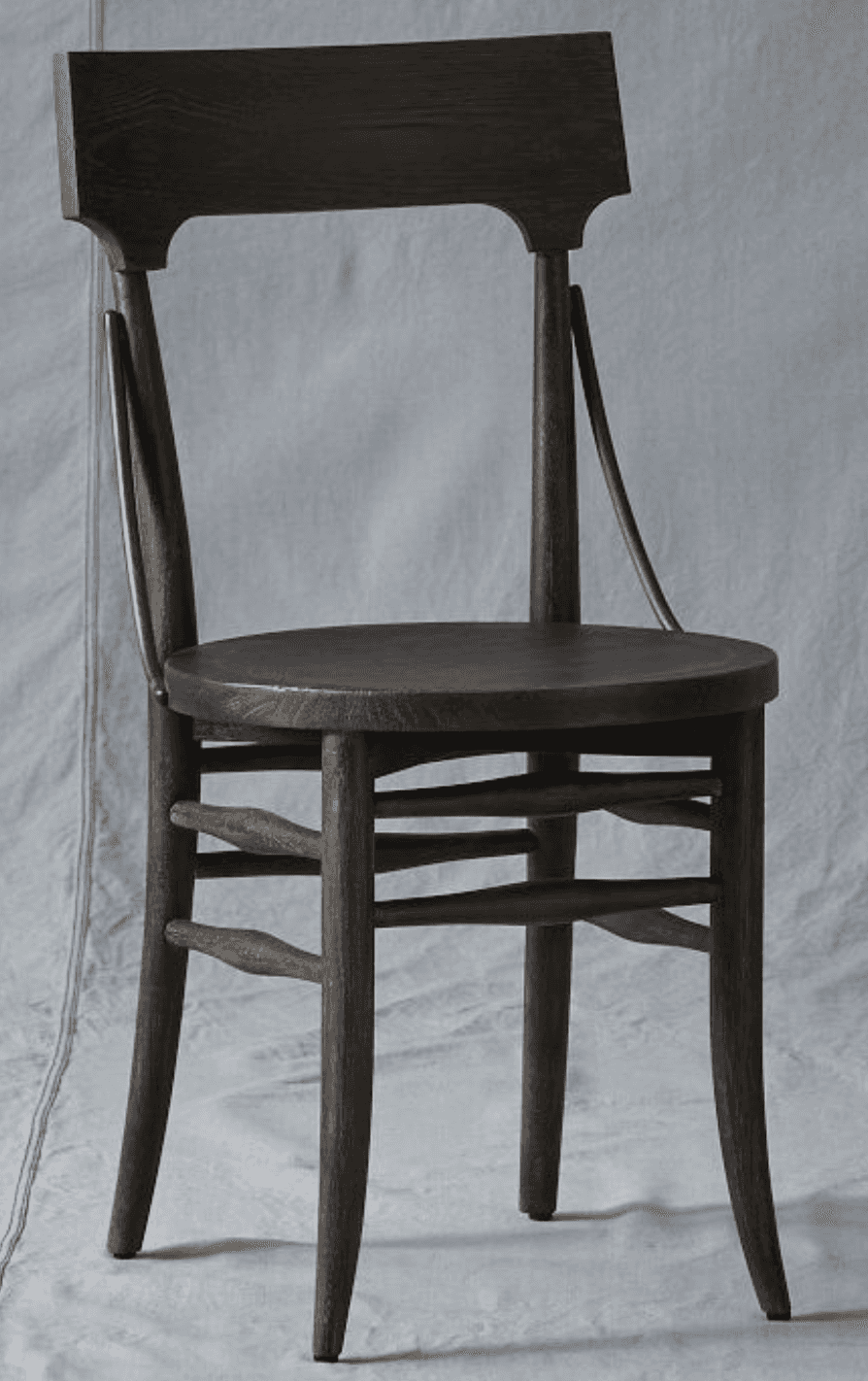 A dark-stained solid wood chair with a gently curved backrest panel and a round seat. The frame feat… — 3D model