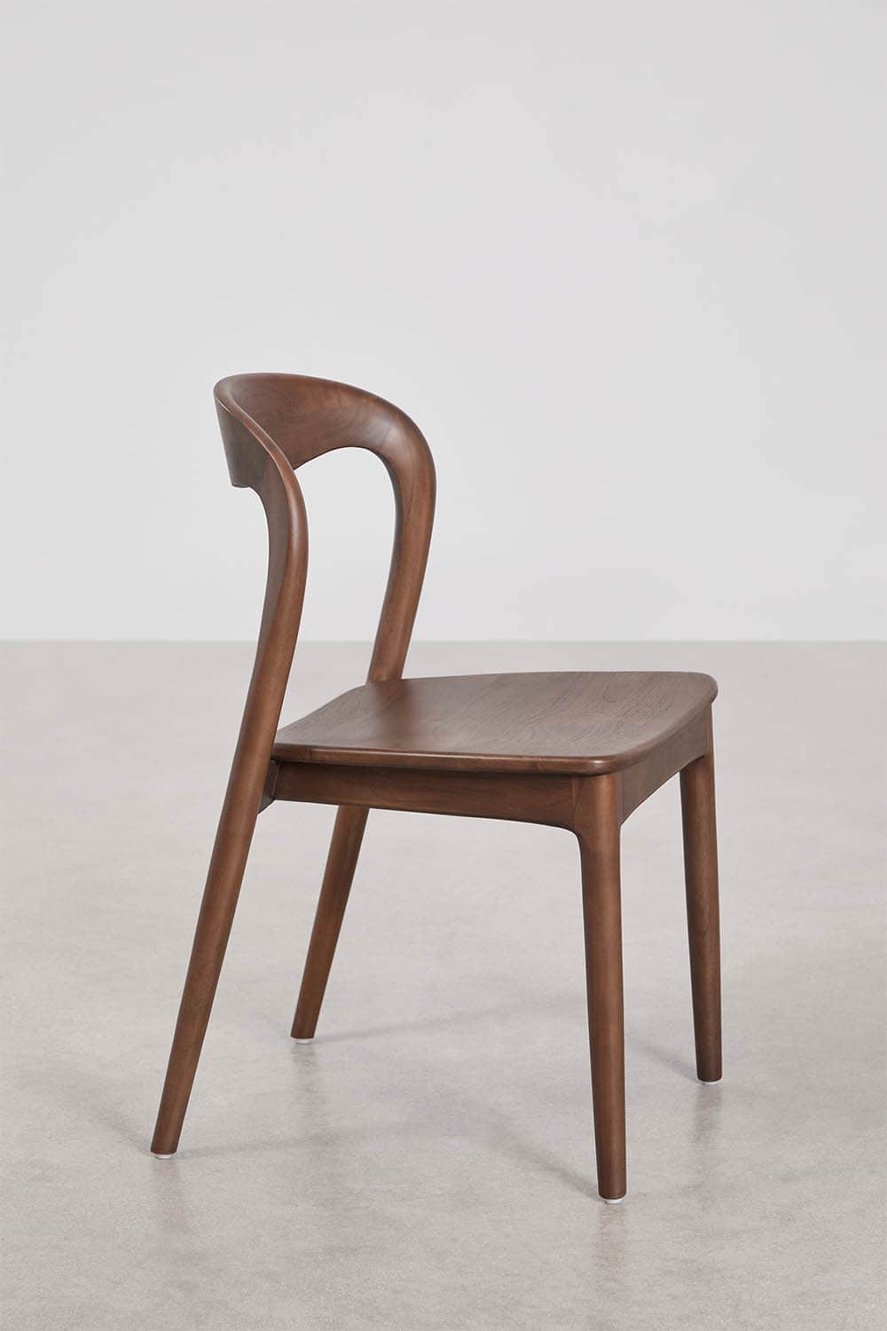 A contemporary dining chair crafted from dark wood, featuring a gracefully curved backrest that seam… — 3D model