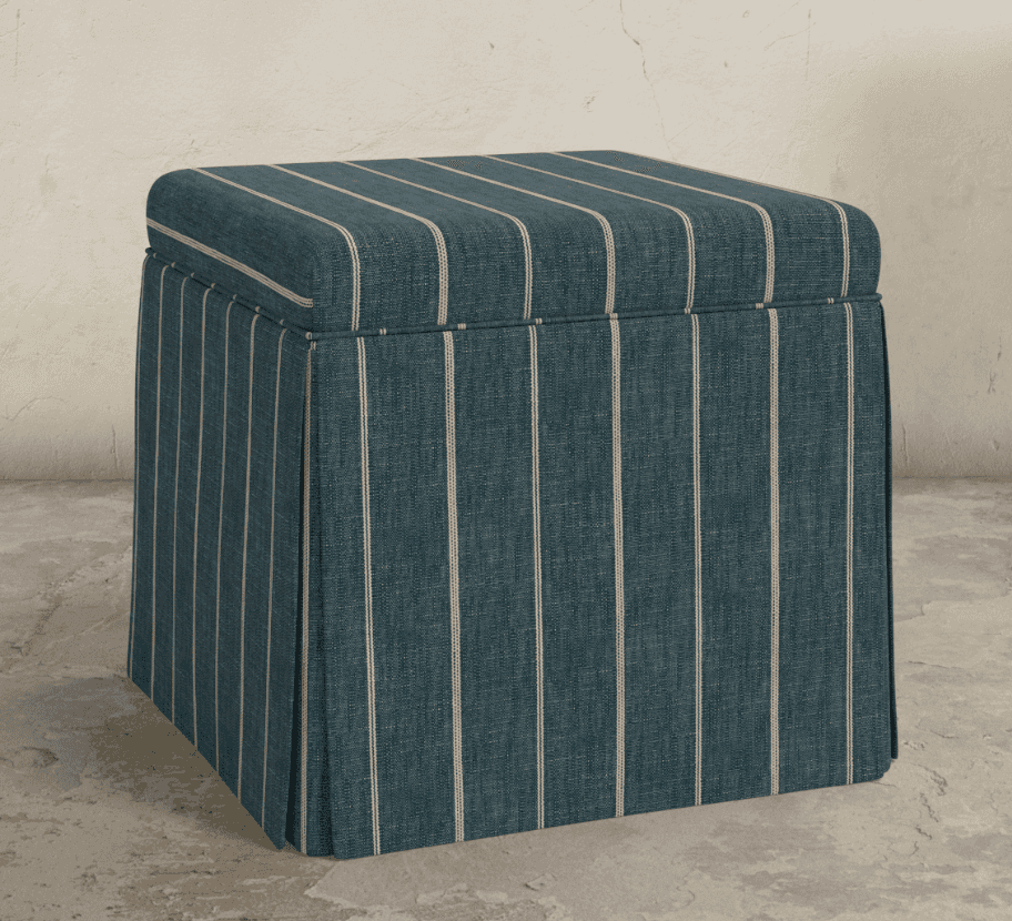 A square, upholstered ottoman featuring a pleated skirt that extends to the floor. The fabric is a d… — 3D model