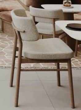 An armless dining chair featuring a light-colored wooden frame and fully upholstered seat and backre… — 3D model
