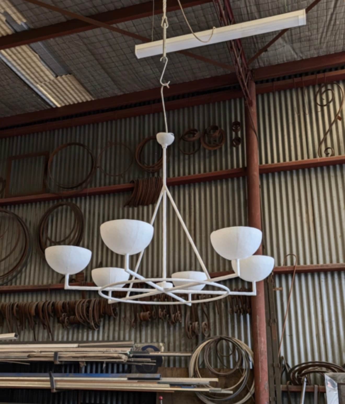 A modern white five-light chandelier featuring a geometric metal frame and five bowl-shaped shades.… — 3D model