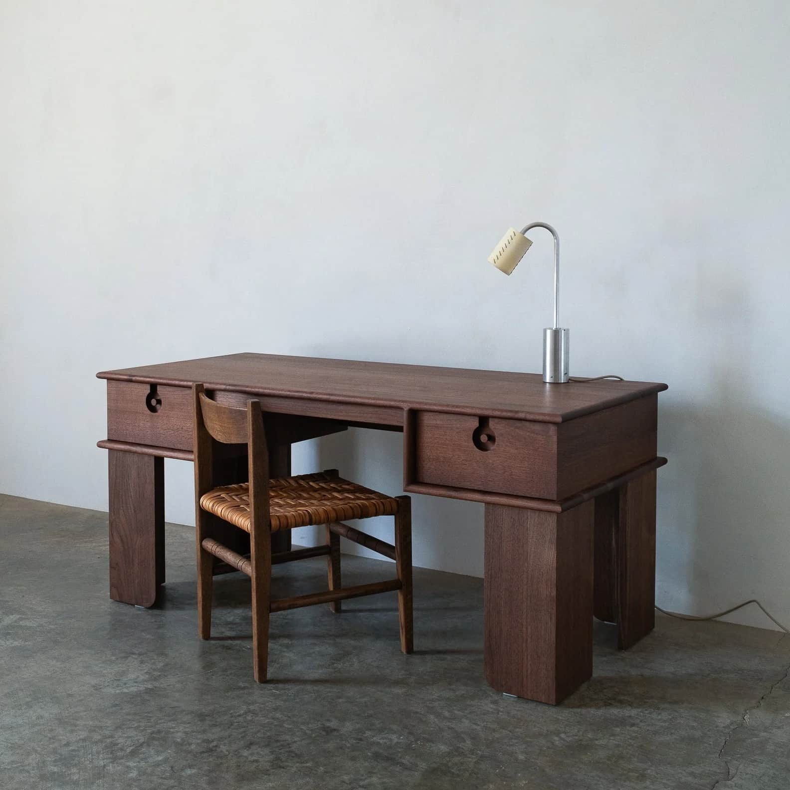 A dark wood desk with a simple, geometric design. It features a rectangular top with two drawers on… — free OBJ 3D model