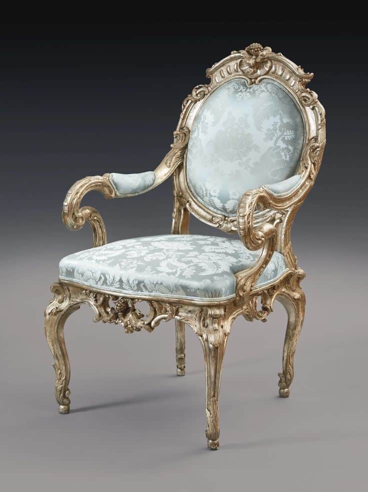 An ornate armchair with a carved wooden frame and upholstered seat and back. The frame features elab… — 3D model