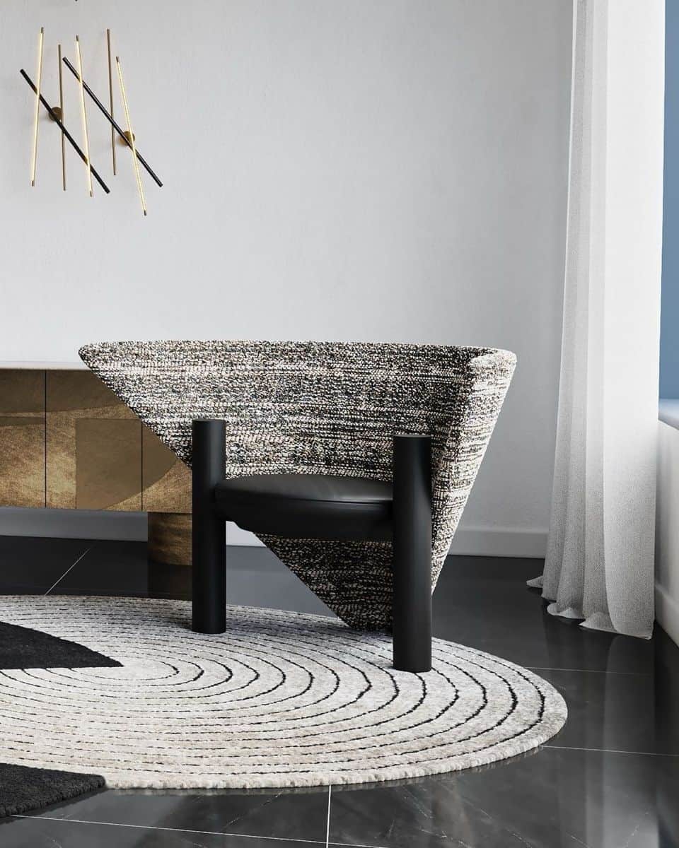 A modern armchair featuring a distinctive, wide, fan-shaped backrest upholstered in a speckled black… — free OBJ 3D model