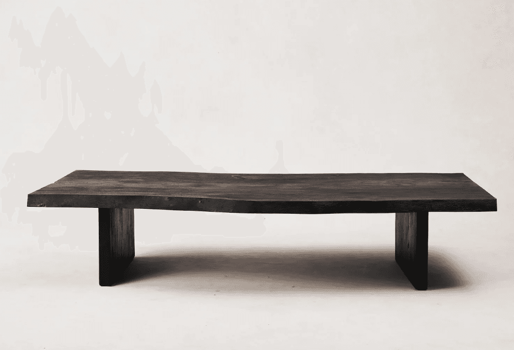 A low, rectangular coffee table with a live-edge top and thick, blocky legs. The tabletop has an irr… — 3D model