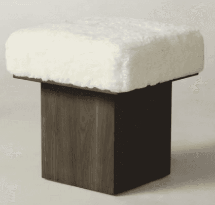 A contemporary square ottoman featuring a thick, plush, white boucle upholstered top, supported by a… — 3D model