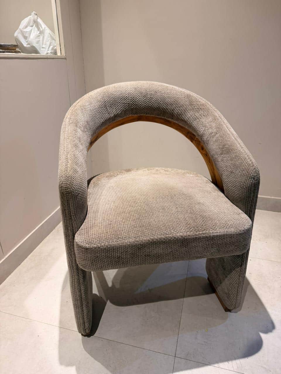 A contemporary armchair with a curved backrest and upholstered seat and arms. The frame appears to b… — 3D model