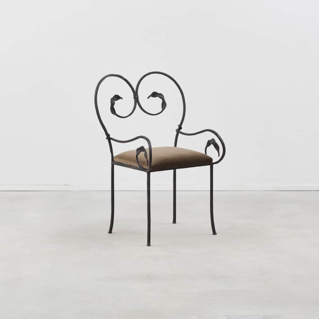 An ornate accent chair featuring a black wrought iron frame with scrolling details and a small, padd… — free OBJ 3D model