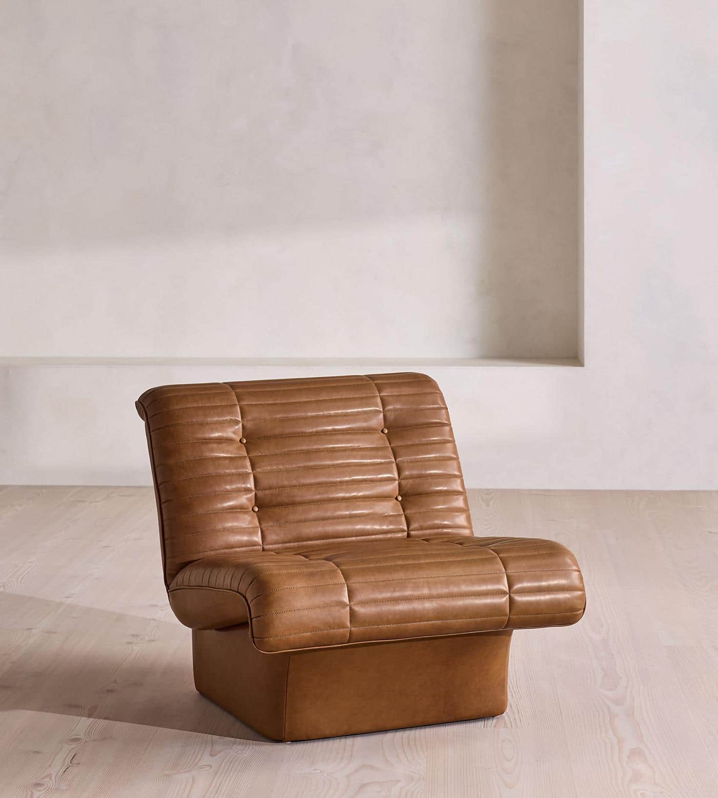 A low-profile armchair upholstered in brown leather with deep channel tufting on the backrest, seat,… — 3D model