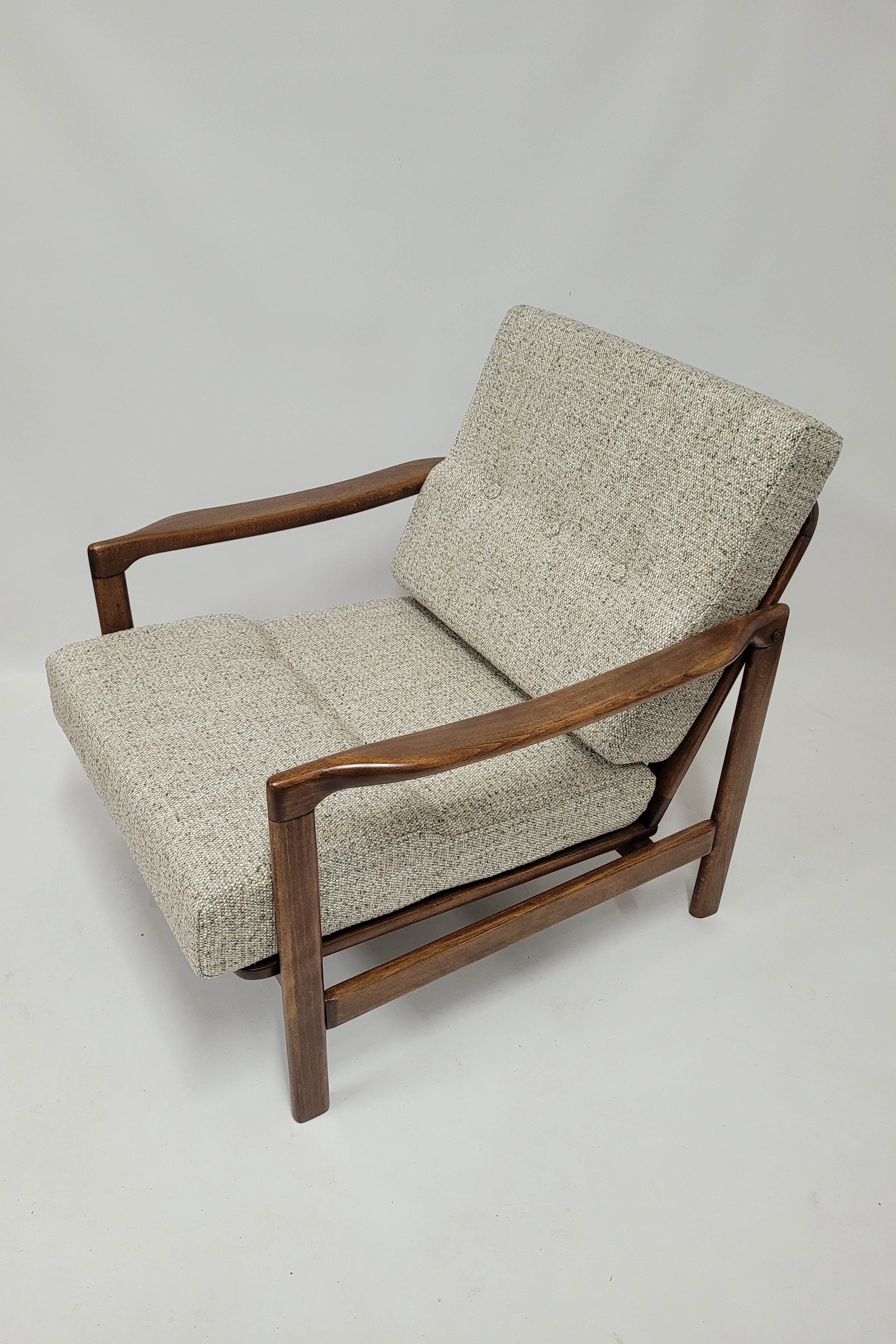 A mid-century modern armchair with a wooden frame and upholstered seating and backrest. The frame ap… — free OBJ 3D model