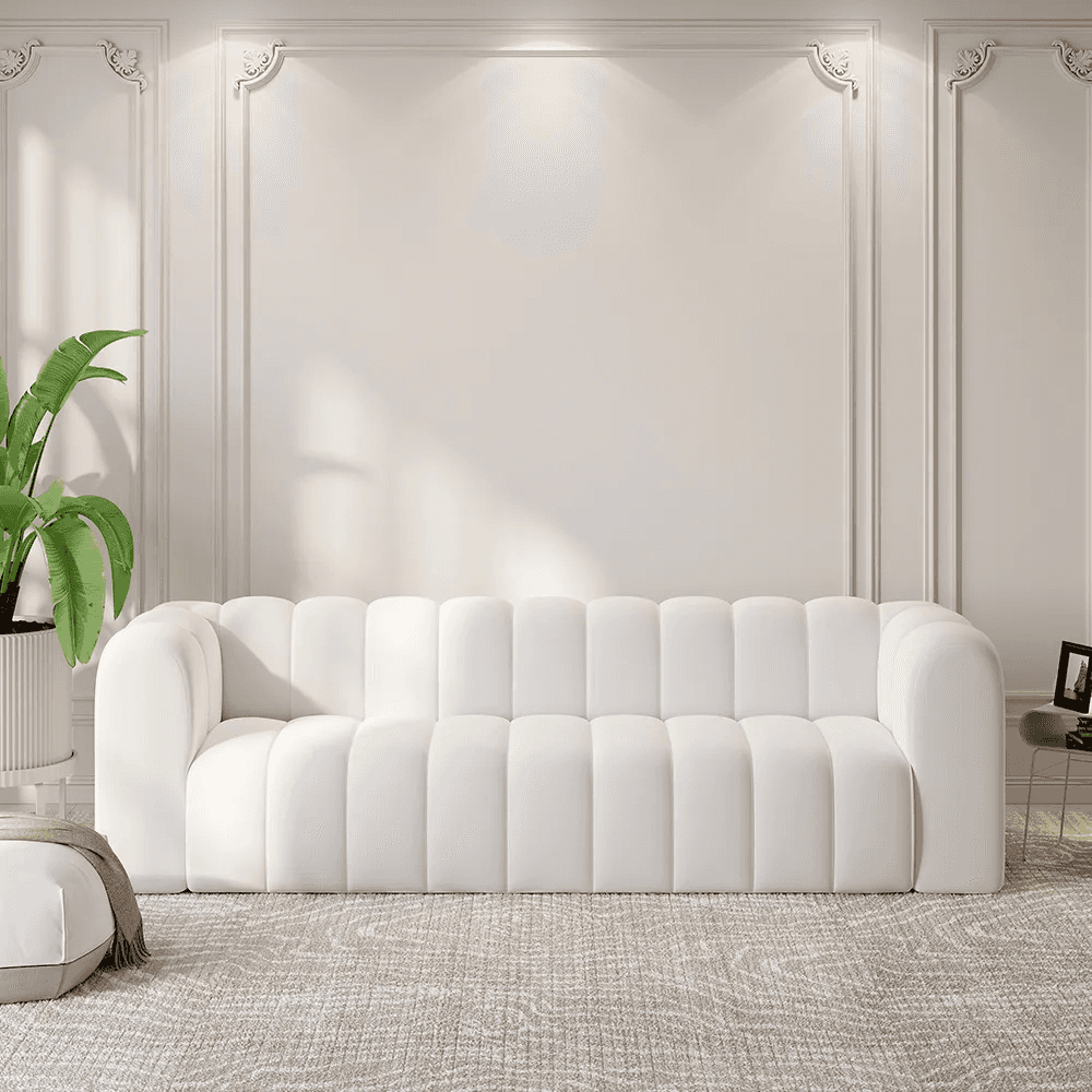 A white, plush sofa with a channel-tufted design across the back and seat cushions. The sofa feature… — 3D model