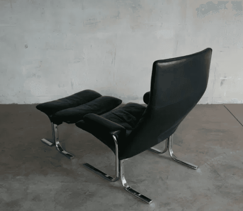 A black leather armchair with a matching ottoman. The chair features a high back and a curved, canti… — 3D model