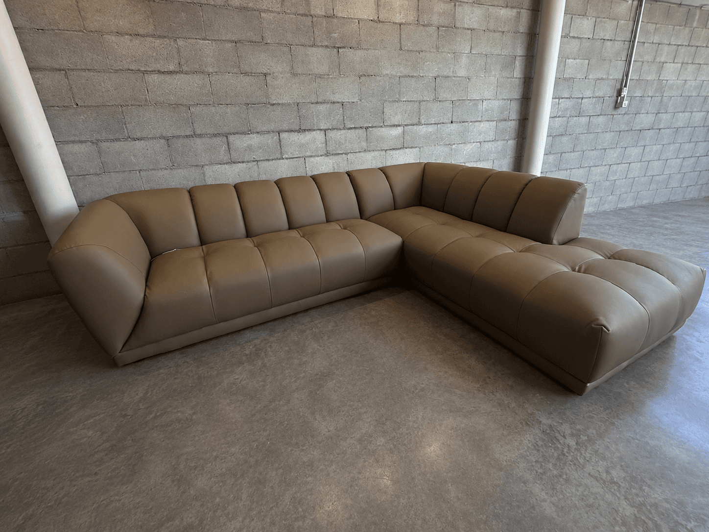 An L-shaped sectional sofa with tan upholstery, featuring individual segmented backrests and seat cu… — 3D model