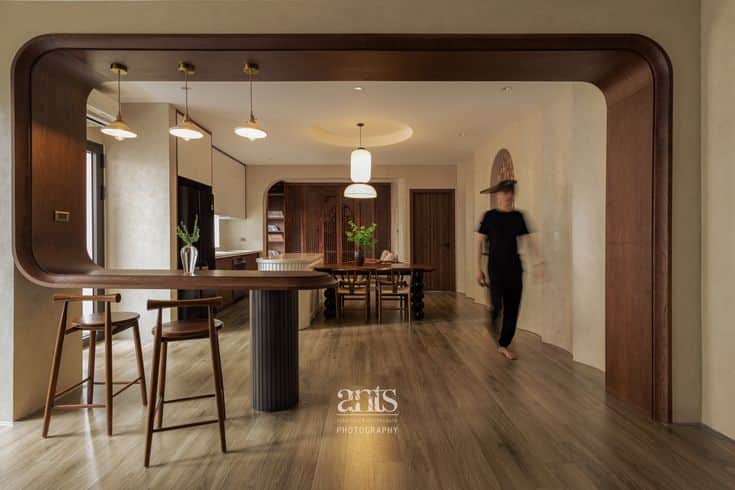 A modern bar set featuring a curved, U-shaped structure with a wooden countertop. Three pendant ligh… — 3D model