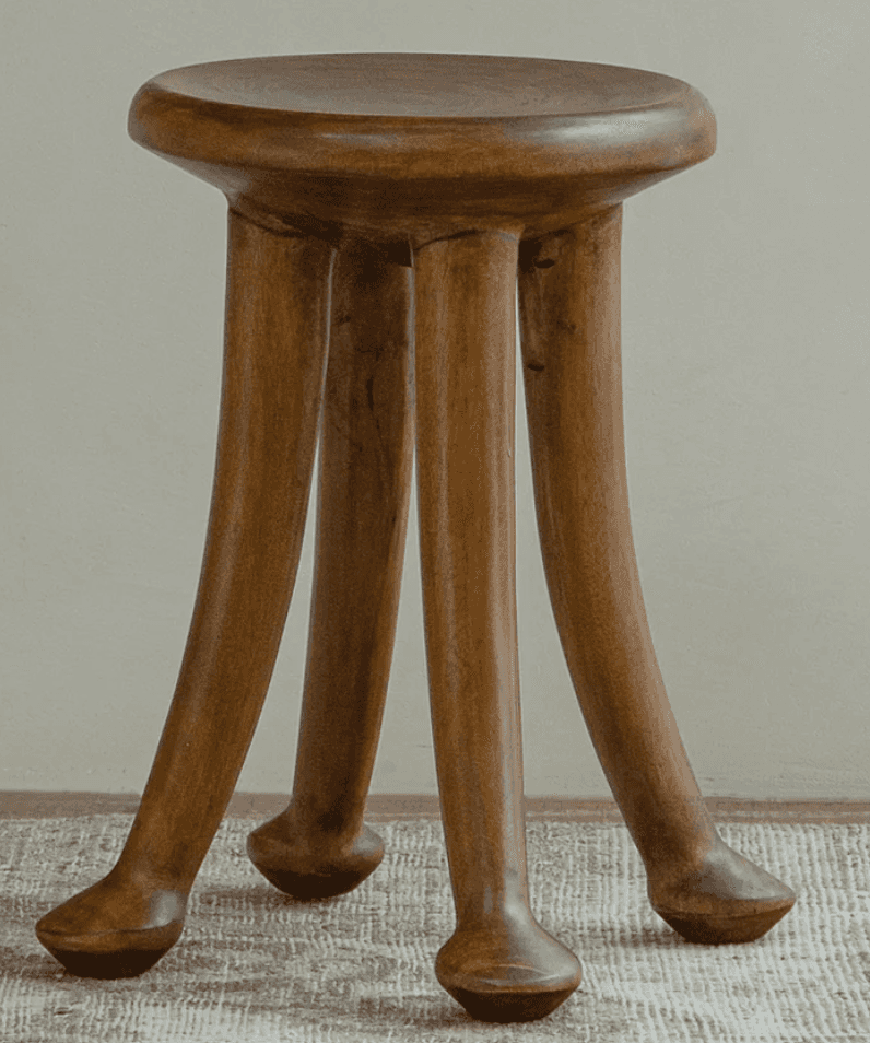 A minimalist wooden stool featuring a circular seat and three splayed, tapered legs with rounded end… — 3D model