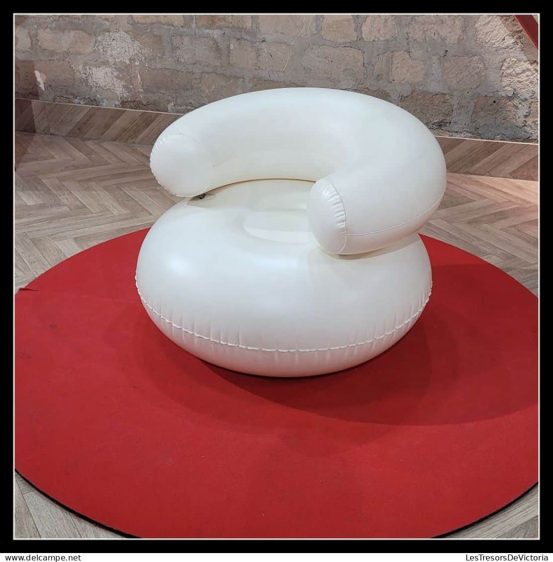 A white, inflatable armchair with a rounded base and a curved backrest that extends forward. The arm… — 3D model
