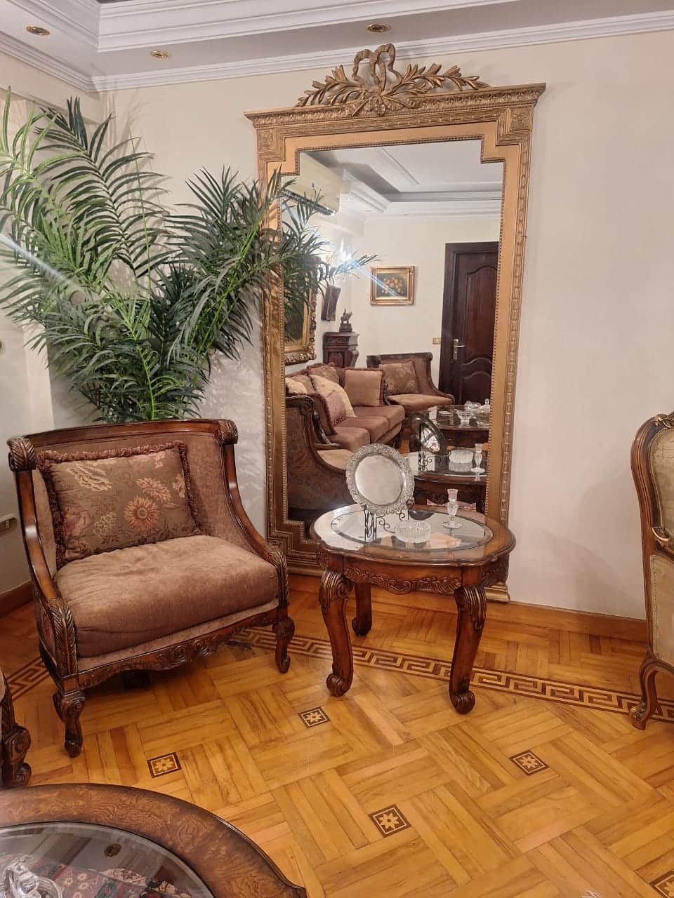 A tall, rectangular wall mirror featuring an elaborately carved and gilded frame, topped with a prom… — 3D model
