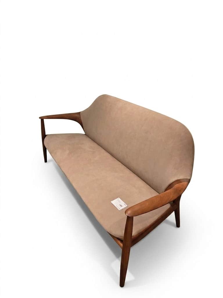 A two-seater sofa or loveseat featuring a visible wooden frame and light beige upholstery. The frame… — 3D model