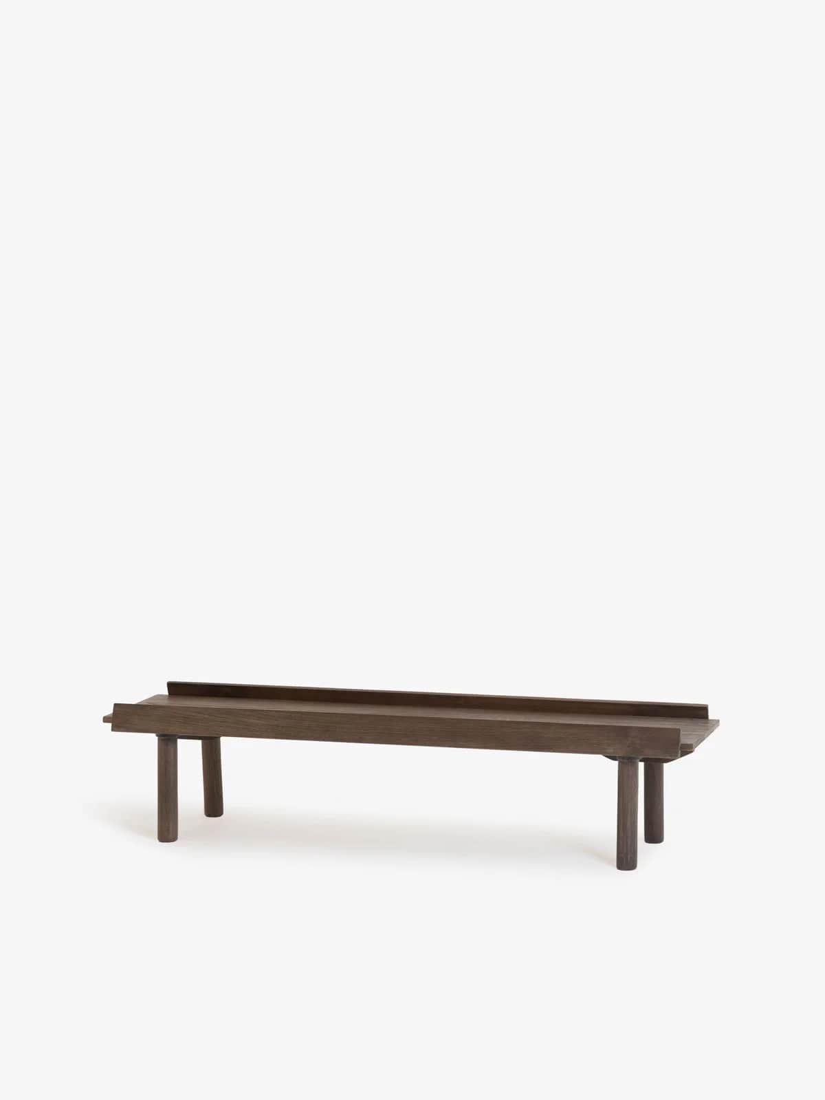 A minimalist wooden bench featuring a long, rectangular top surface with a raised edge along its len… — 3D model
